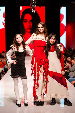 Models and designer Cardiovascuwhore posing at the end of the runway.