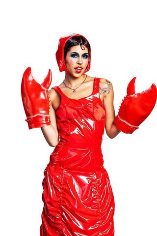 Model wearing red pleather dress, hat and lobster claws from designer Cardiovascuwhore. 