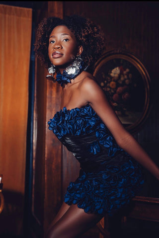 Fashion model wearing blue dress and statement earrings from Elu by Elon.