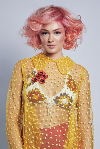 Fashion model with pink hair wearing yellow shear top with crochet bralette by Sky Barker Maa.