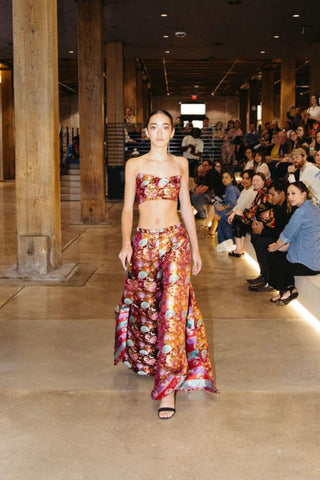 Model walking the runway wearing a floral two-piece outfit from fashion brand Thenso.