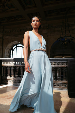 Model wearing a flowing light-blue dress by fashion designer Yet Luxxe.