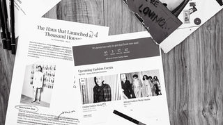 Various papers of inspiration for ShowHaus on a wood surface in black and white.